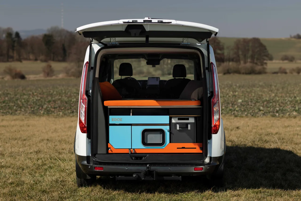 Pohled do zadní části bílého vozu s kempingovou vestavbou.