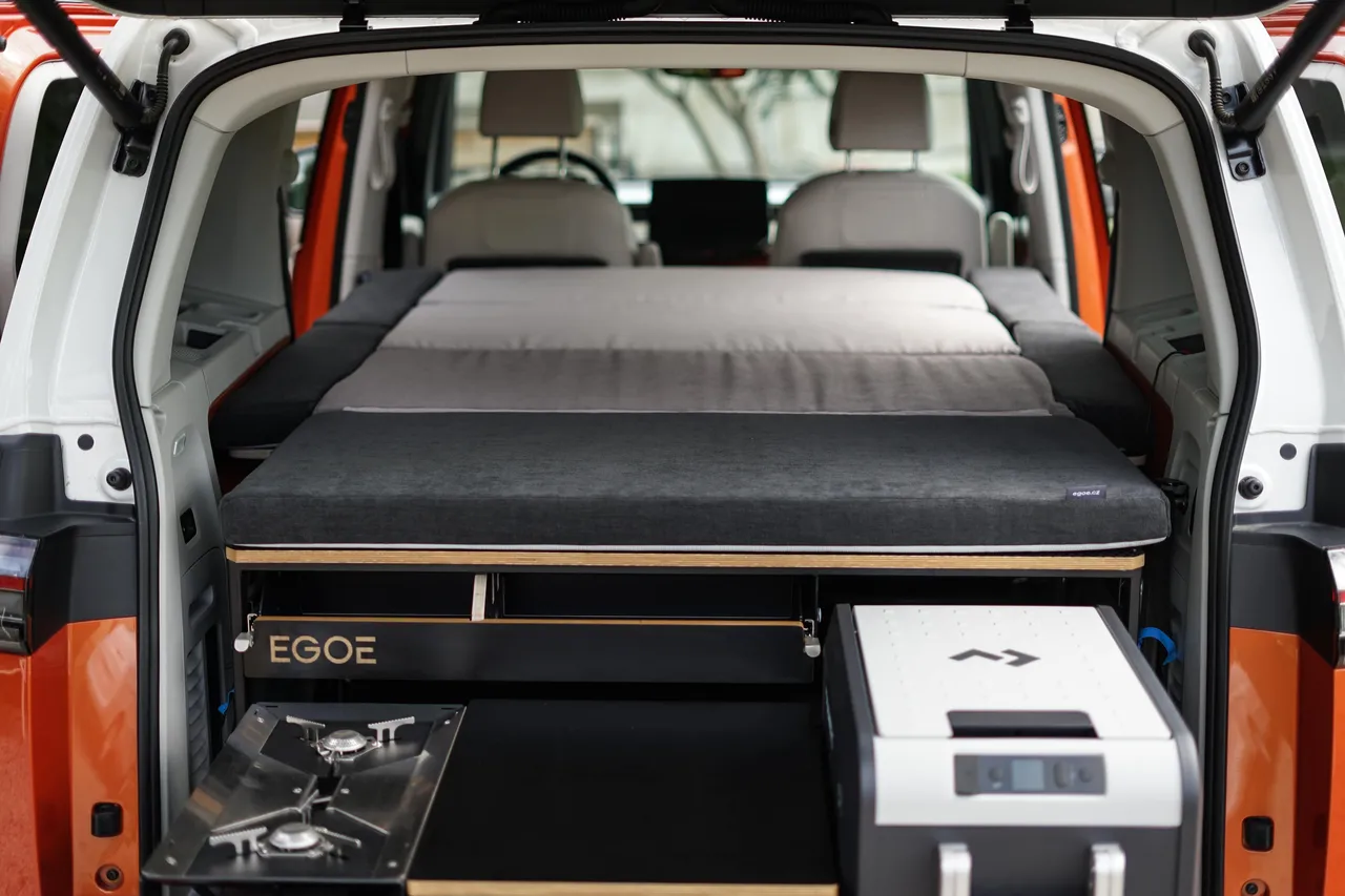 Pohled do zadní části bílého vozu s kempingovou vestavbou.
